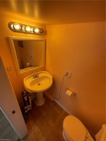 Bathroom with toilet and baseboards