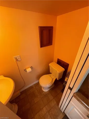 Bathroom featuring toilet and baseboards