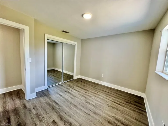 Unfurnished bedroom with a closet and wood finished floors