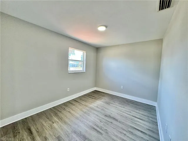 Spare room with baseboards and wood finished floors