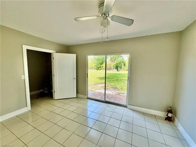 Empty room with light tile patterned floors and a ceiling fan