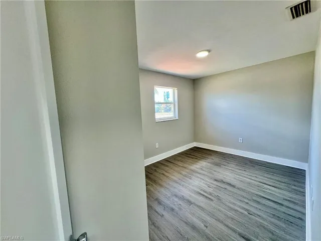 Empty room featuring wood finished floors and baseboards