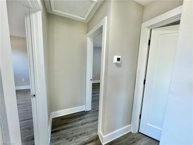 Hallway featuring dark wood-type flooring and attic access