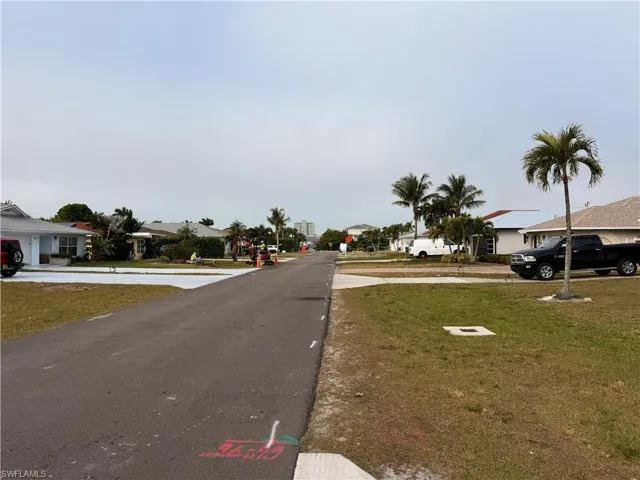 View of asphalt street with a residential view and traffic signs
