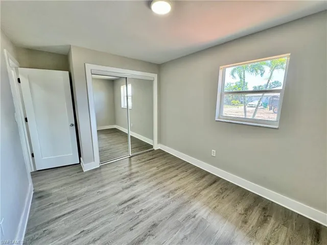 Unfurnished bedroom with wood finished floors and a closet