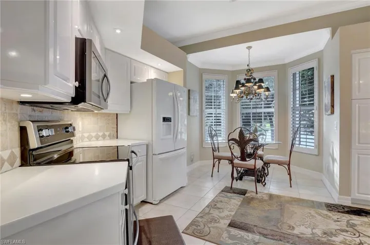Kitchen featuring white cabinets, light tile patterned floors, stainless steel appliances