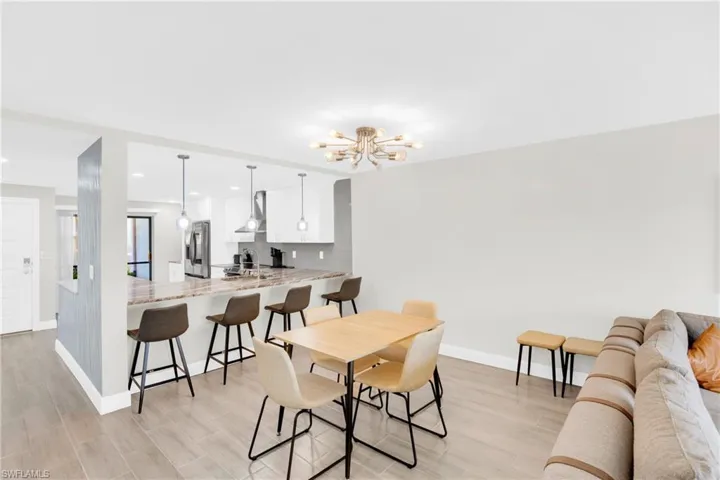 Dining space with wood tiled floors, a chandelier, and recessed lighting