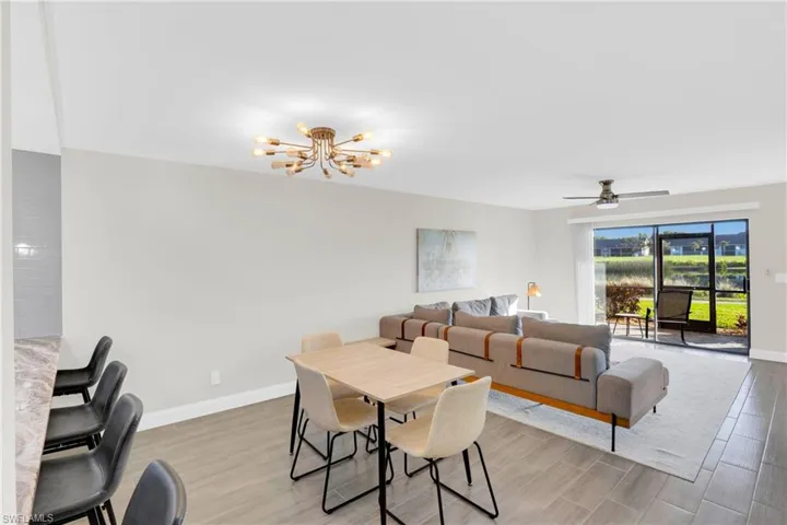 Dining area with a chandelier, wood tiled floors, and a ceiling fan