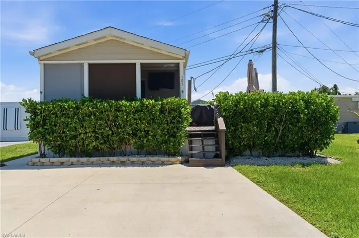Front of property with paved driveway and steps to Deck