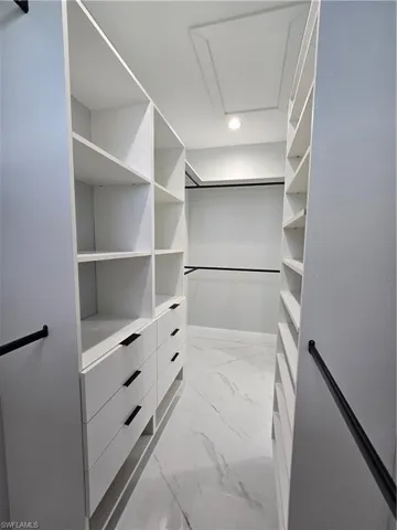 Walk in closet with light tile floors