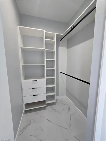 Spacious closet with light tile floors
