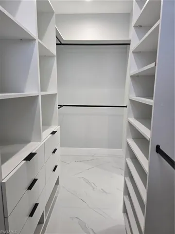 Spacious closet featuring light tile floors