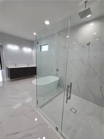 Bathroom with tile flooring and shower with separate bathtub