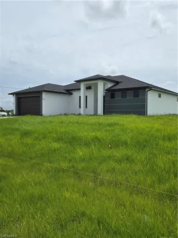 View of front facade with a garage and a front lawn