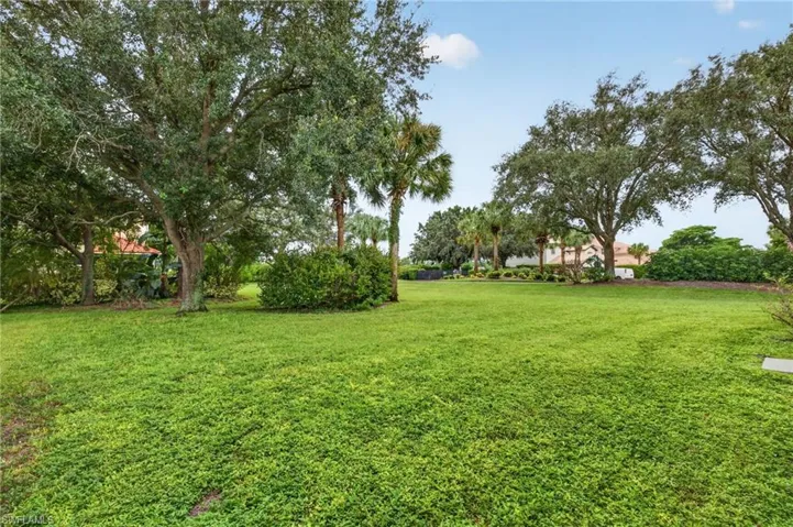 Expansive green lawn with mature trees and tropical foliage