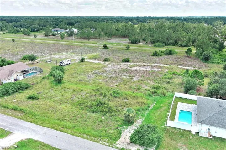 View of rural area with a pool area and a forest