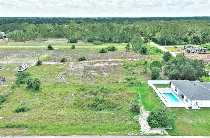 View of rural area featuring a heavily wooded area and a pool area
