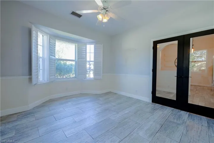 Unfurnished room with french doors, a ceiling fan, visible vents, and baseboards