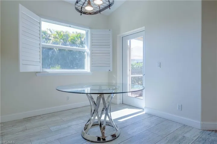 Unfurnished dining area with baseboards, plenty of natural light, and wood tiled floor