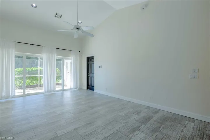 Empty room featuring baseboards, visible vents, a ceiling fan, light wood-type flooring, and high vaulted ceiling