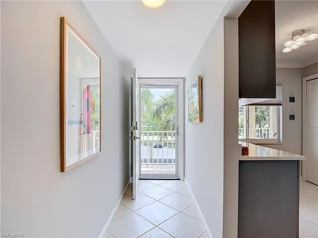 Bright entryway featuring diagonal tile flooring and a doorway opening to a white railing