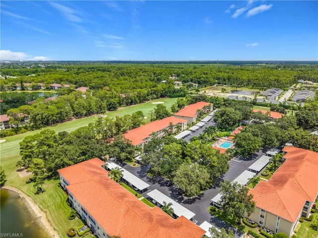 Aerial perspective featuring multiple low-rise structures with tile roofs, surrounded by dense greenery