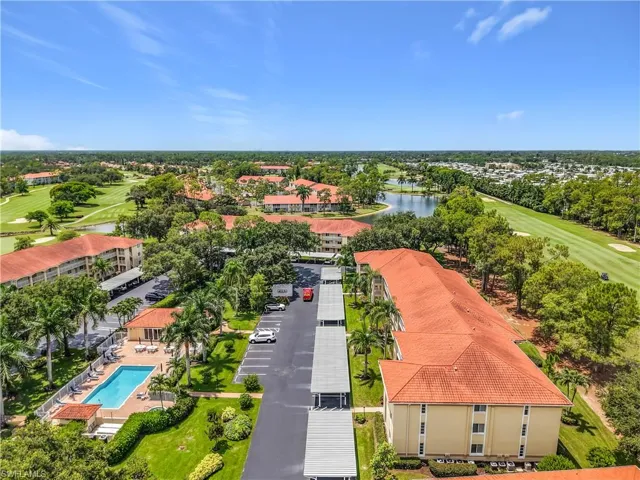 Expansive aerial perspective showcasing multiple residential buildings with terracotta-style roofing, surrounded by lush green landscaping