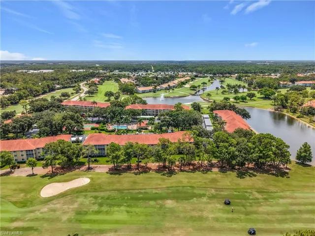 Expansive golf course property featuring multiple water features, mature trees, and red tile roof structures