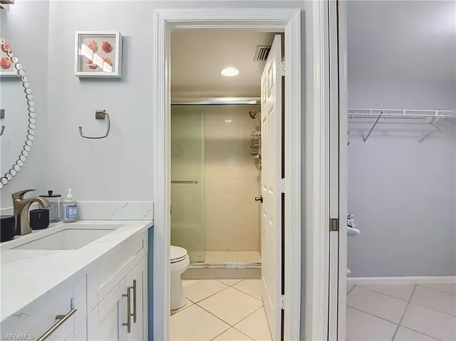 Bathroom vanity featuring a single basin, brushed nickel faucet, and white countertop