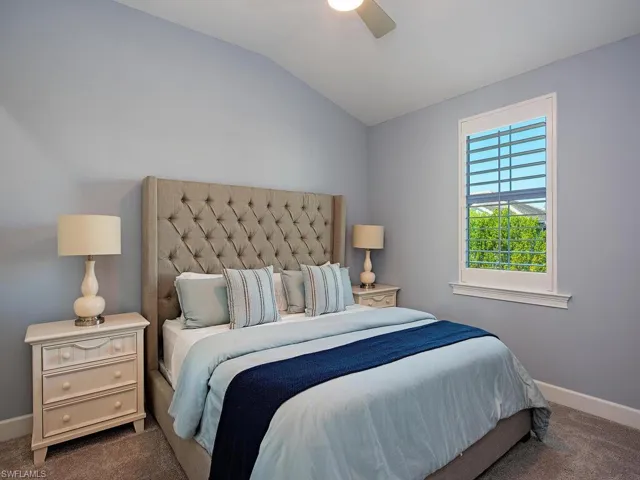 Bedroom with vaulted ceiling, carpet flooring, and ceiling fan