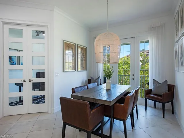 Dining space featuring french doors, crown molding, and light tile patterned floors