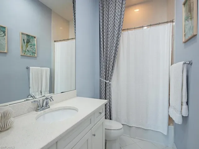 Bathroom with vanity, light tile patterned floors, and shower / tub combo