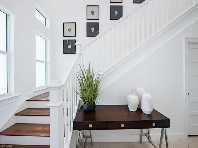 Staircase with tile patterned flooring and baseboards