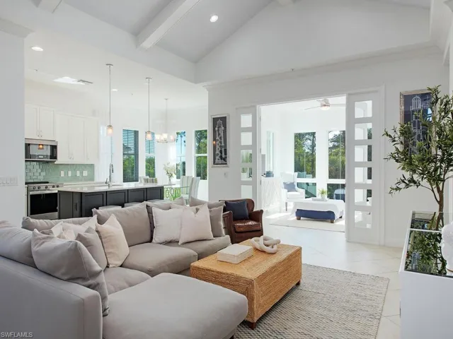 Living room featuring a chandelier, beam ceiling, healthy amount of natural light, recessed lighting, and light tile patterned floors