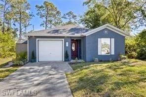 Ranch-style home with an attached garage, stucco siding, driveway, and a front yard