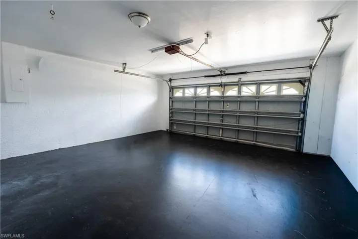 Garage featuring electric panel and a garage door opener
