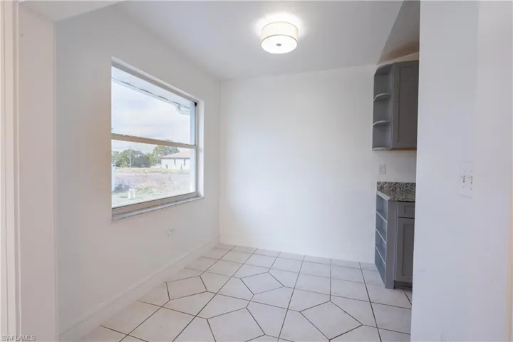 Unfurnished dining area featuring baseboards and light tile patterned floors