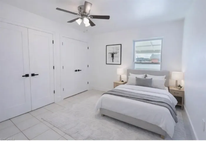 Staged - Guess bedroom featuring multiple closets, a ceiling fan, and light tile patterned floors