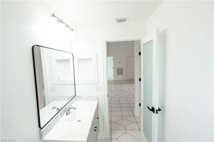 Guess bathroom with vanity and light tile patterned flooring