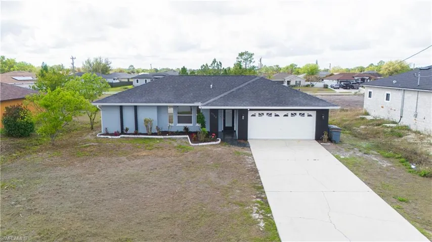 Ranch-style house featuring roof with shingles, concrete driveway, a garage, and a residential view