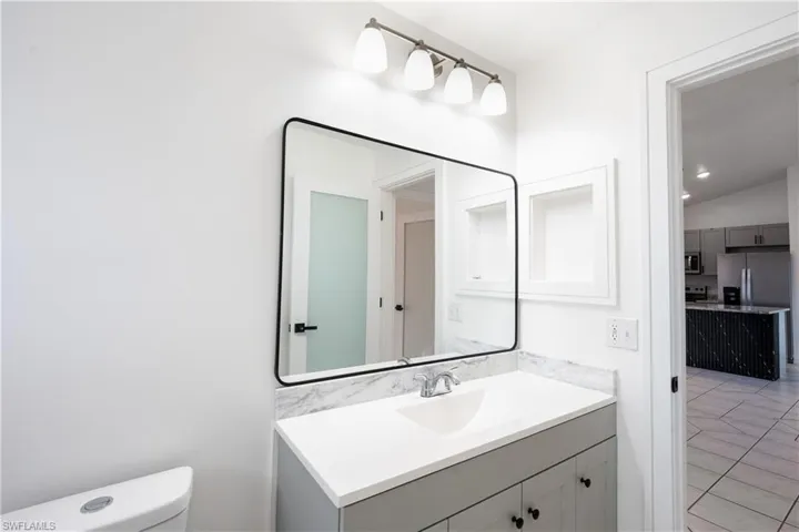 Guess bathroom featuring mirror and vanity