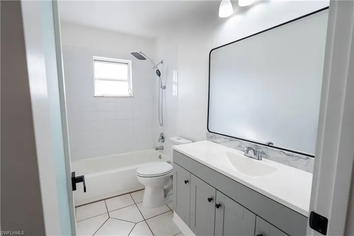 Full guess bath with vanity, shower / bathtub combination, and light tile patterned flooring