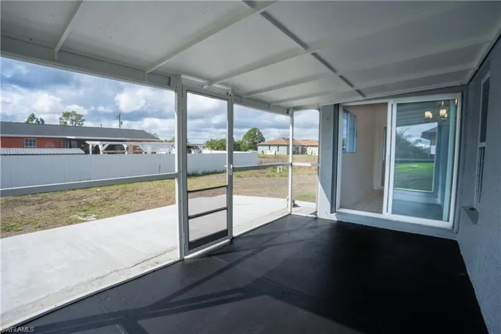 Unfurnished sunroom with a patio area, healthy amount of natural light, and a residential view