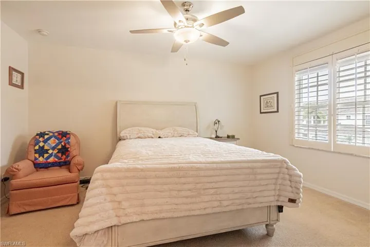 Bedroom with light colored carpet and ceiling fan
