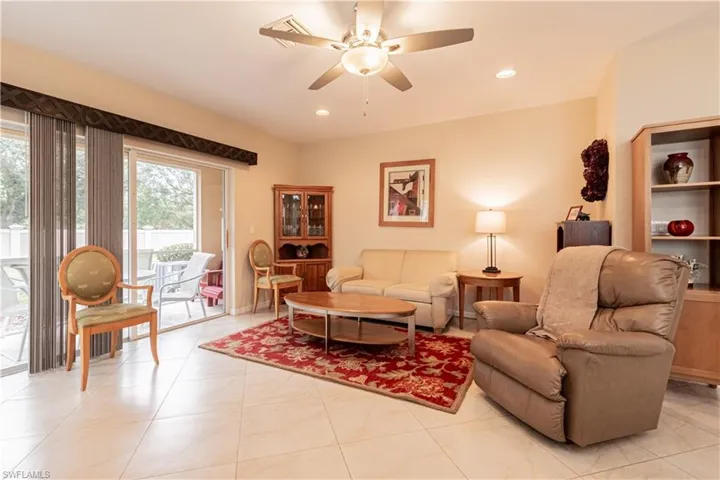 Living room with light tile patterned flooring and ceiling fan