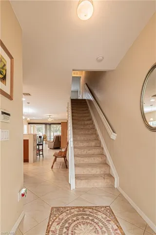 Staircase with ceiling fan and tile patterned floors
