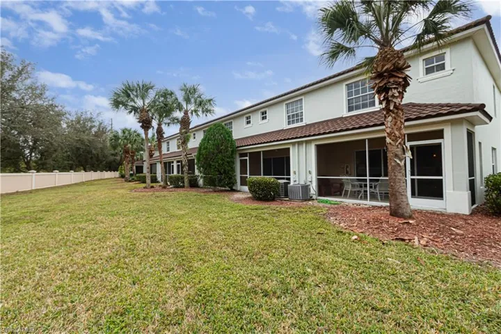 Rear view of property with central AC, a yard, and a sunroom
