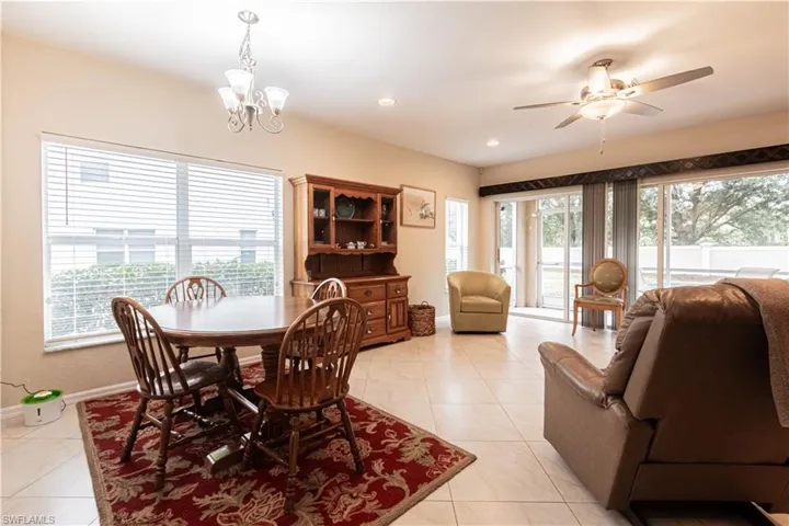 Dining room featuring light tile patterned flooring and ceiling fan with notable chandelier