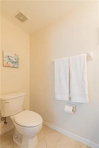 Bathroom with toilet, tile patterned flooring, and a textured ceiling