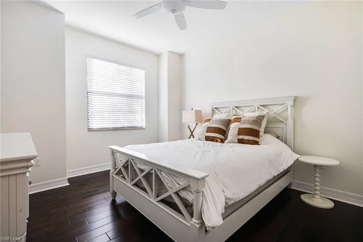 Bedroom with dark hardwood / wood-style floors and ceiling fan